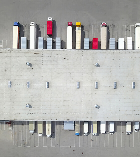 An aerial view of semitrucks parked at a truck loading doc